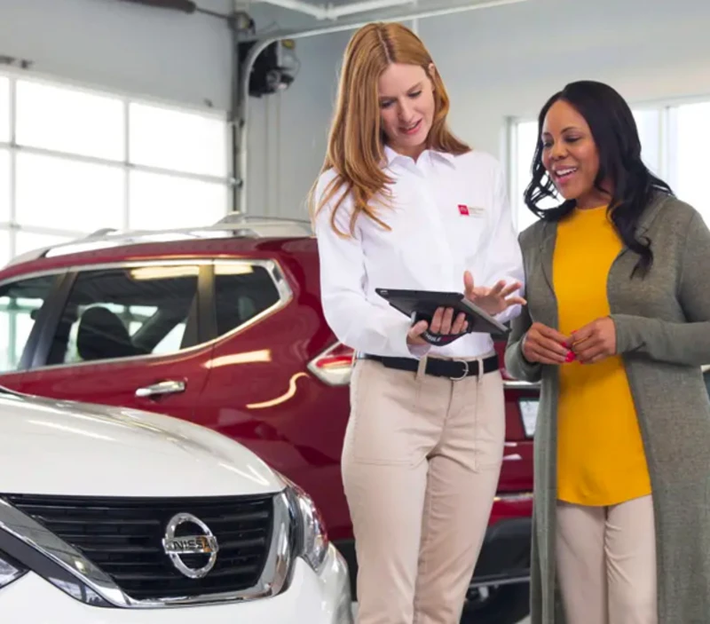 Nissan representative discussing vehicle information with a customer