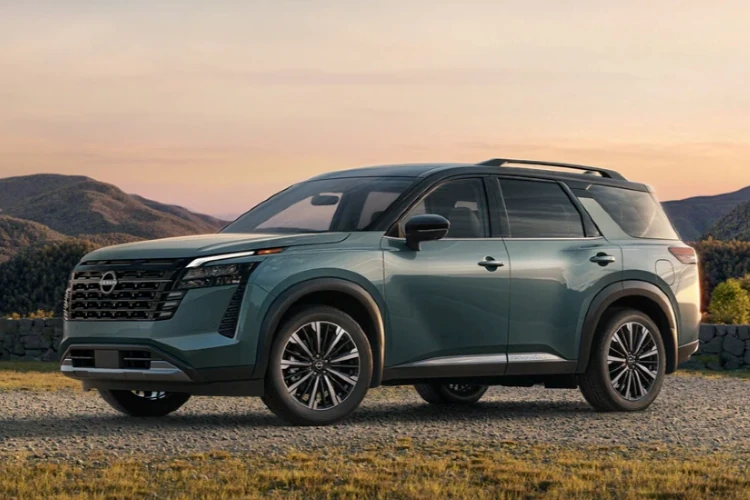 Green Nissan SUV parked in a landscape at sunset