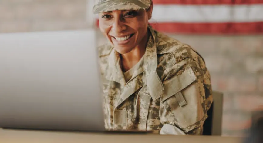 Service member smiling at desk