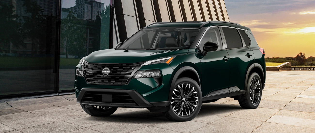 Green Nissan Rogue parked outside a modern building at sunset