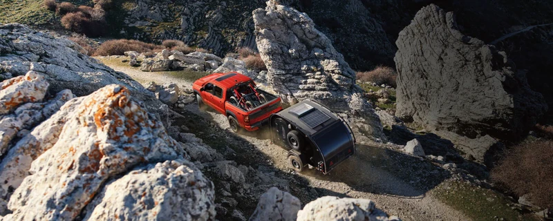 Nissan Frontier towing a trailer across rocky terrain