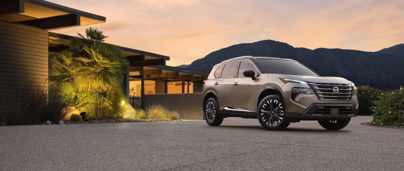 Nissan Rogue parked outside a modern home at sunset