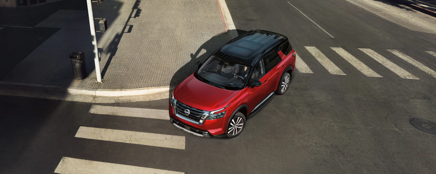 Red Nissan Pathfinder SUV at an intersection