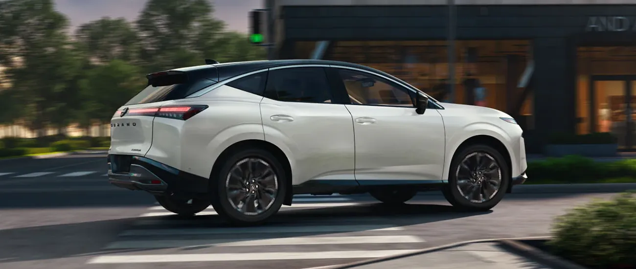 White Nissan Murano driving through a city