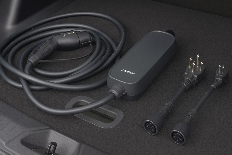 Coiled portable charge cable and adapters laid out on a dark surface