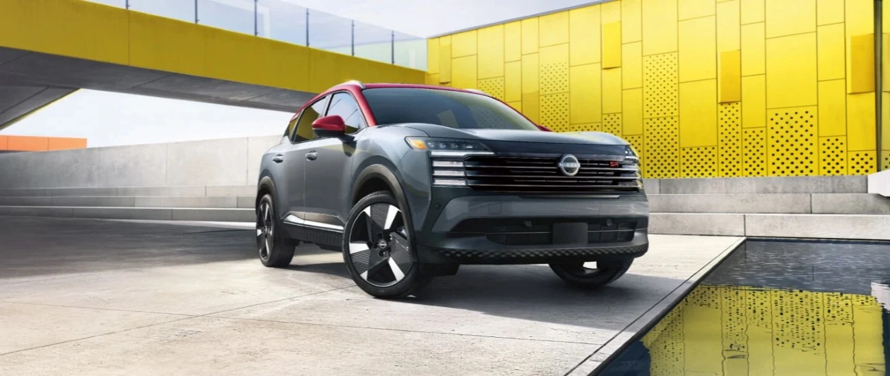 Grey Nissan Kicks parked in front of a yellow architectural backdrop