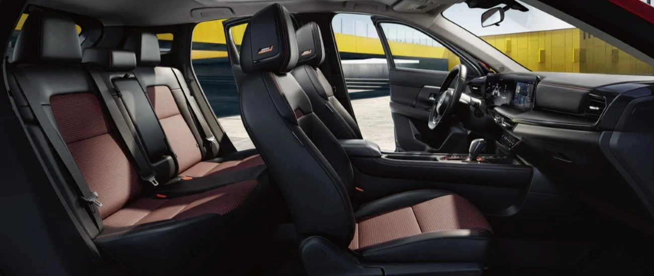 Cutaway view of the Nissan Kicks cabin showing the front and rear seats in two-tone upholstery