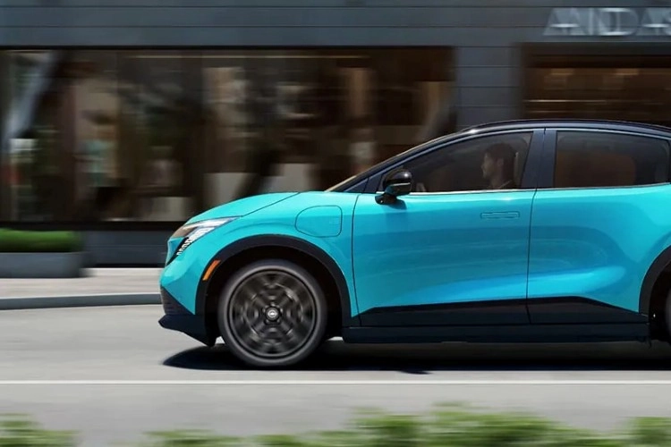Teal Nissan LEAF in motion, shown in profile