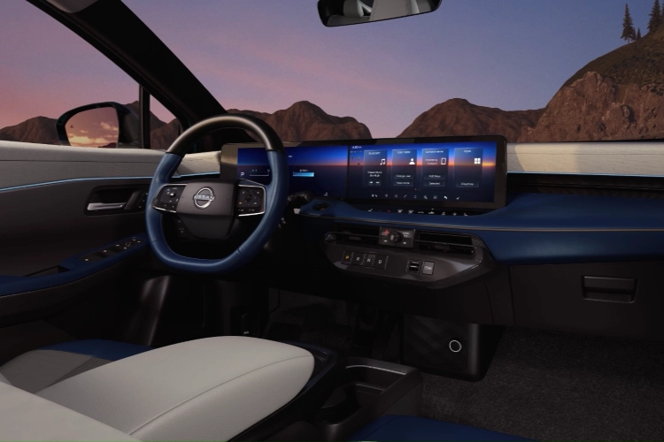 Nissan LEAF cabin at dusk showing the steering wheel and widescreen displays