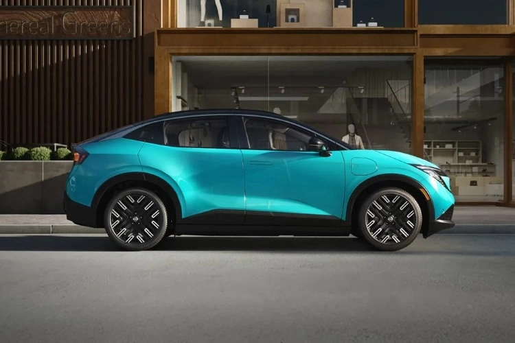 Teal Nissan LEAF parked outside a building at night