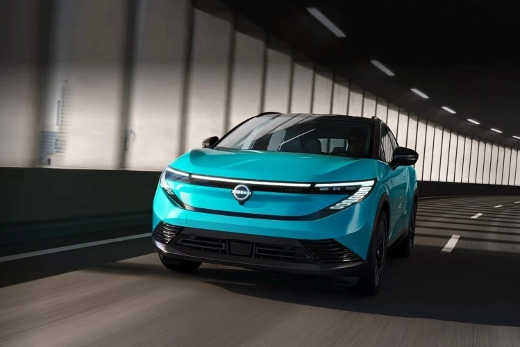 Teal Nissan LEAF driving through a tunnel, seen from behind
