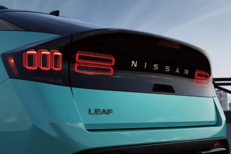 Rear detail of a teal Nissan LEAF showing the taillights and LEAF badge