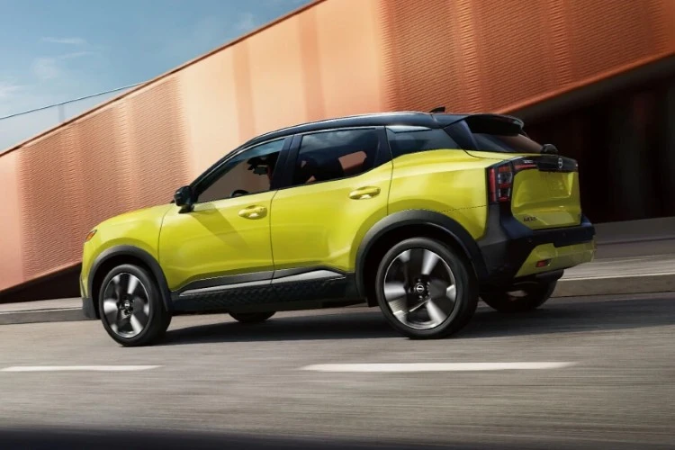 Lime green Nissan Kicks travelling alongside a concrete barrier