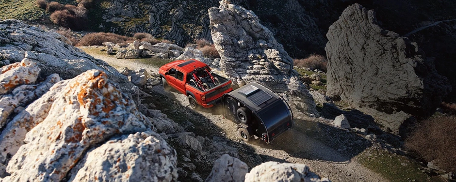 Red and dark Nissan vehicles on a rocky trail