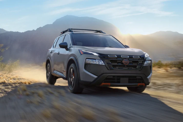 Gray Nissan SUV driving through a mountainous landscape