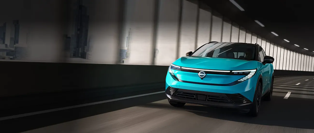Turquoise Nissan electric SUV driving through a tunnel